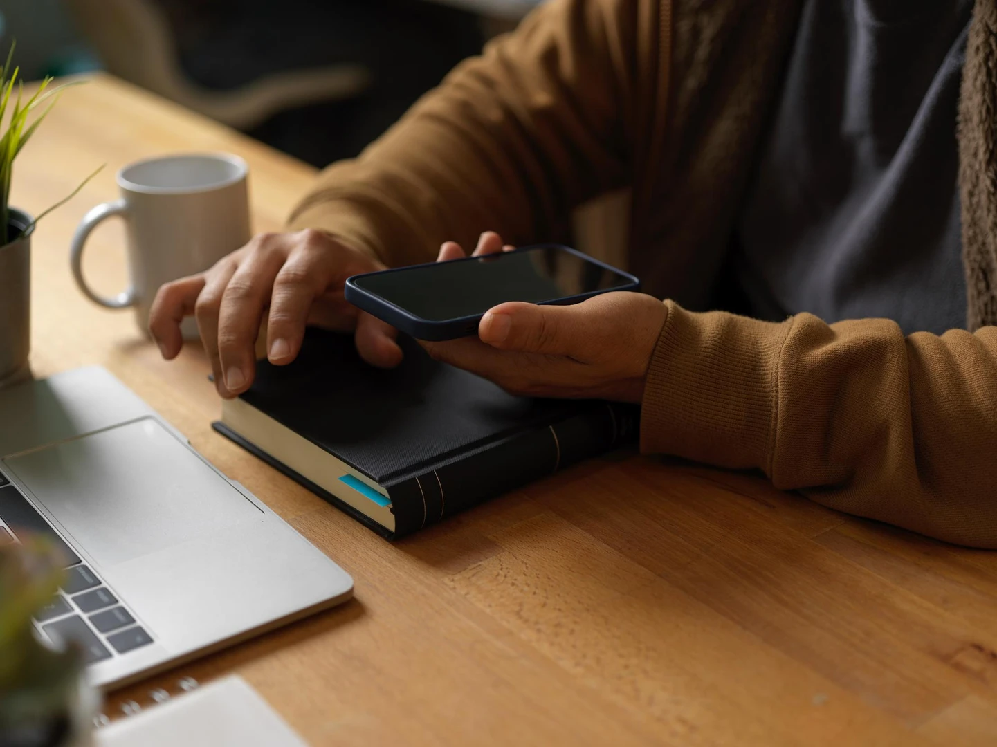 Midsection of man using smart phone on table